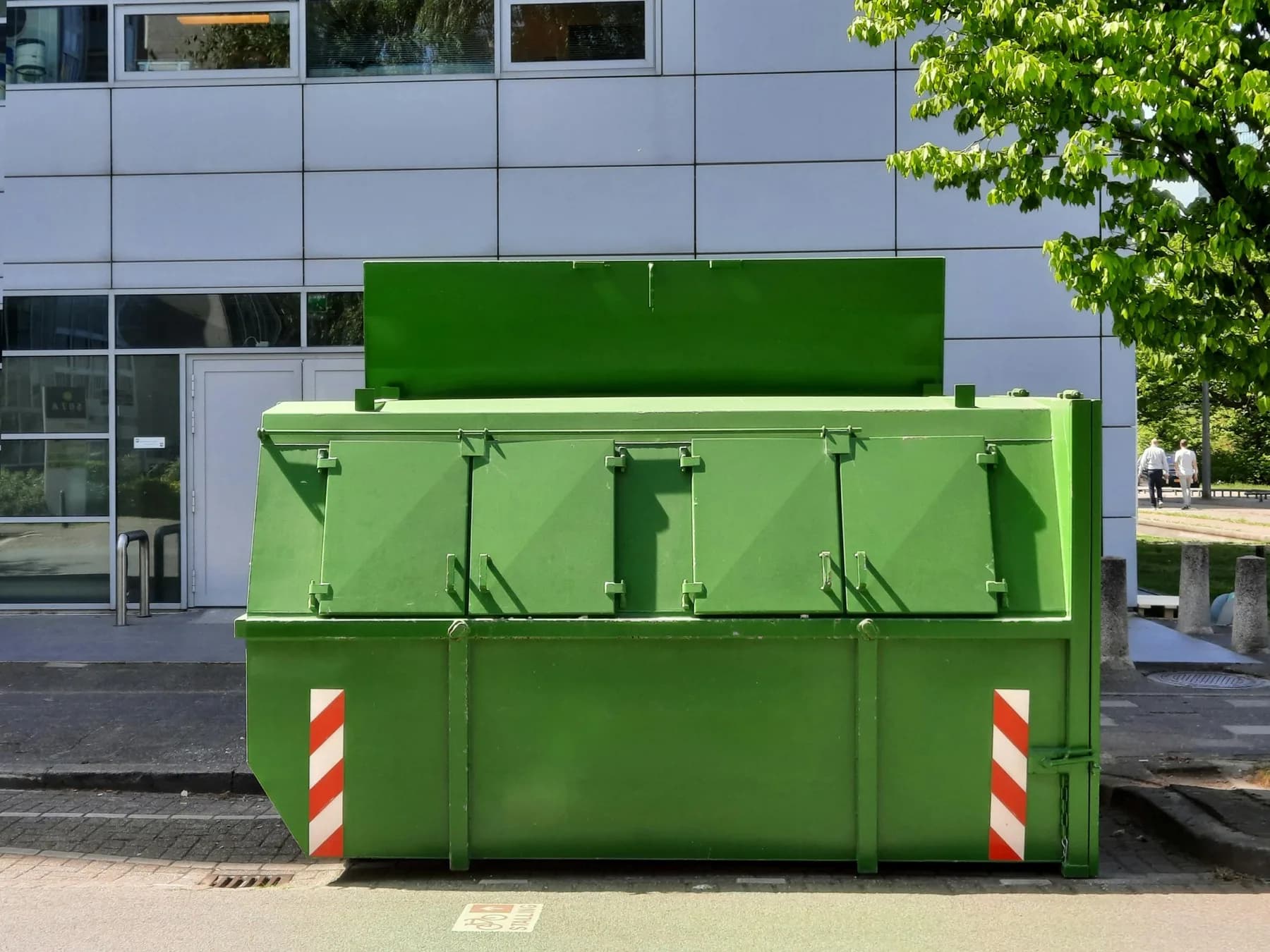 Green roll-off dumpster on a residential lot — accepted materials guide
